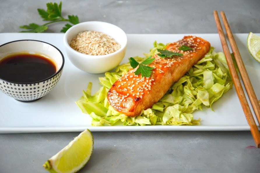 Sesampanerad laxfil� p� en b�dd av vitk�l. 