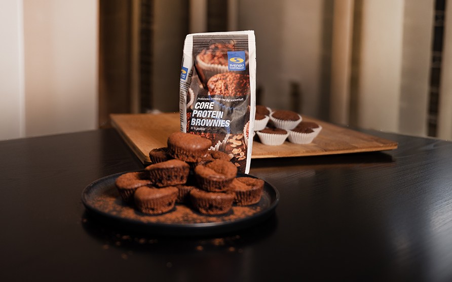 F�rdigbakade proteinbrownies p� ett fat, med en p�se Core Protein Brownies bakmix i bakgrunden.