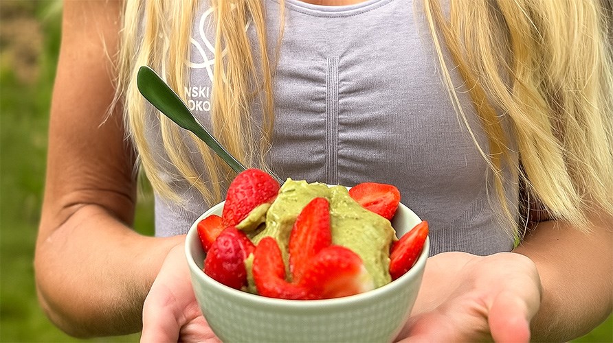 Josefine Dyall hller i en skl med Matcha Nice Cream med halverade jordgubbar som topping.
