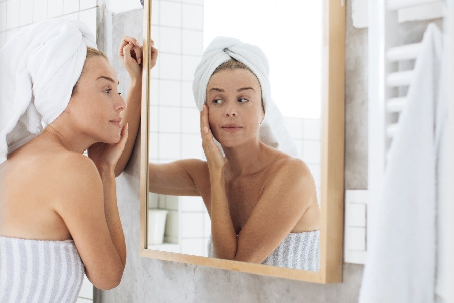 Kvinna i badrum smrjer in ansiktet.