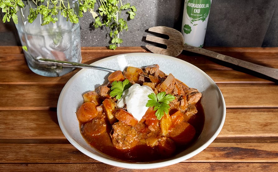 Gryta med ktt, potatis, mortter, passerade tomater, vitlk och timjan serverad p en vit tallrik.