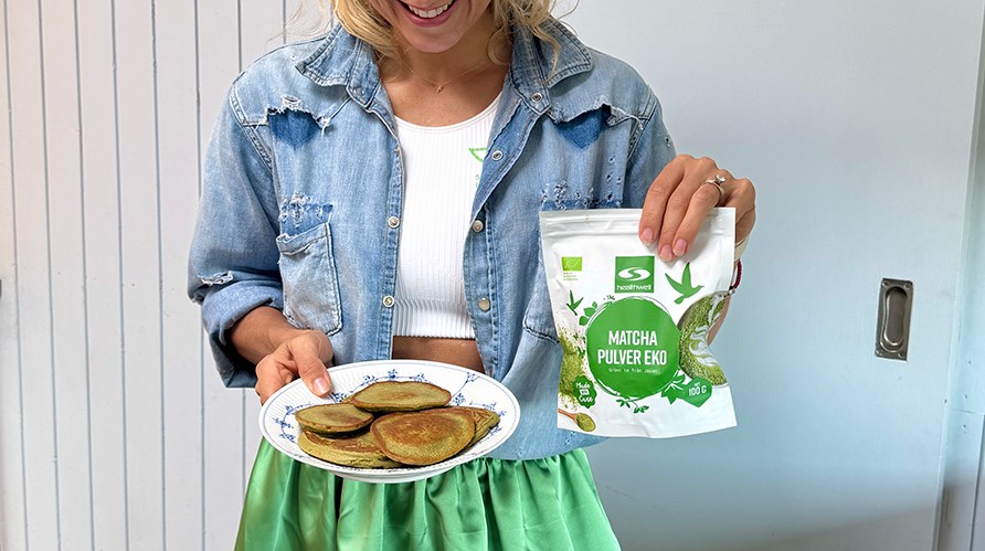 Johanna Hector hller i en tallrik med matchapannkakor och i Healthwell Matcha Pulver EKO.