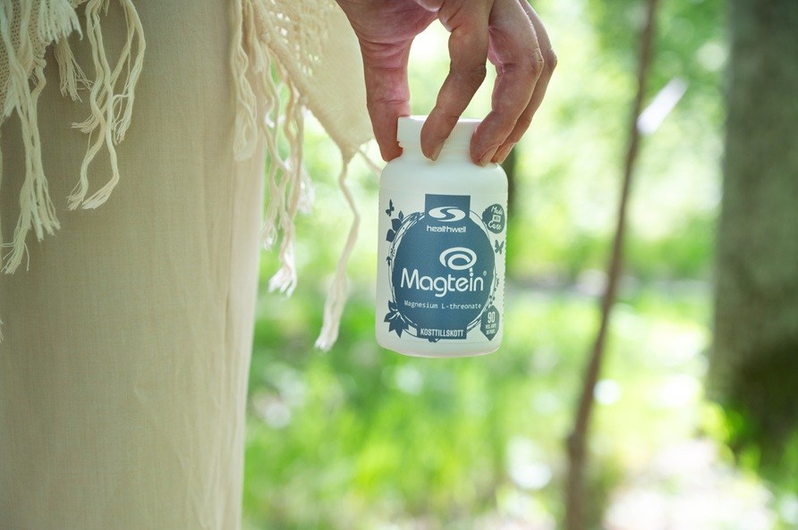 En hand h�ller i en burk Healthwell Magtein. 