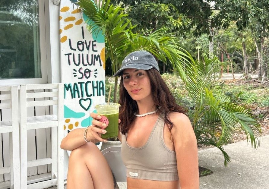 Alicia Gustavsson sitter på en bänk med en grön juice i handen. I omgivningen finns palmer. Alicia Gustavsson sitter på en bänk med en grön juice i handen. I omgivningen finns palmer.