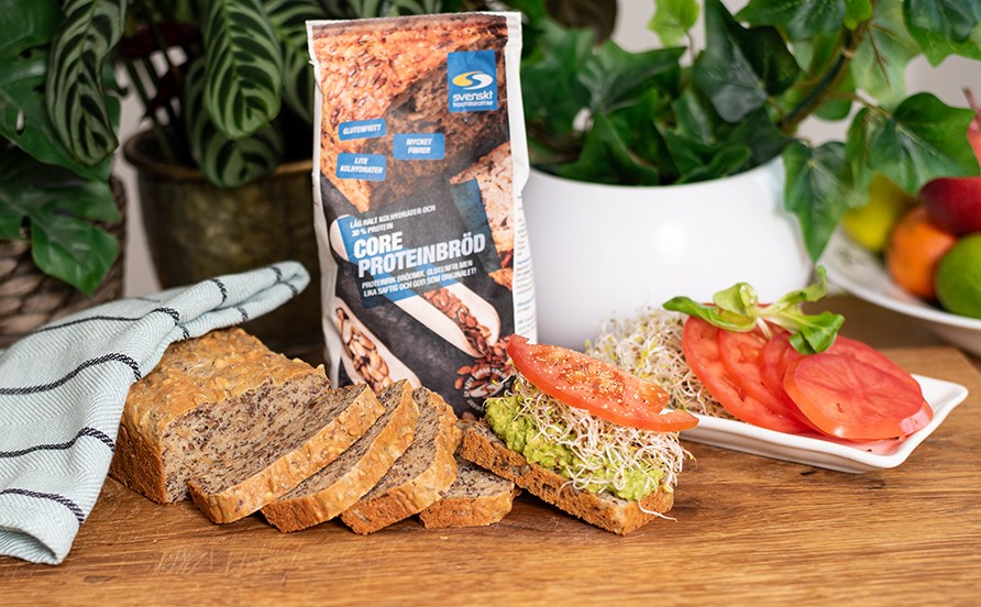 Proteinbrd uppskuret och uppdukat p trbrda. En skiva r garnerad med tomat, acokado och groddar.