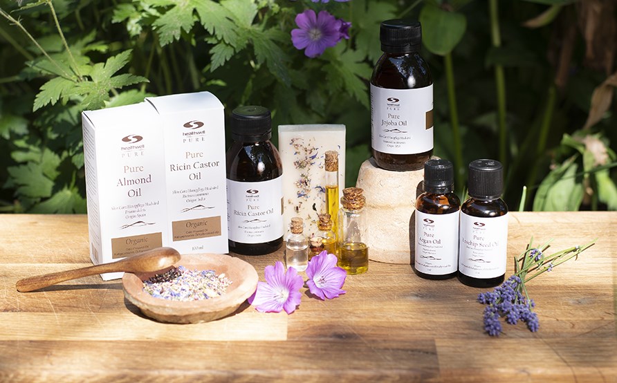 Flera flaskor med naturliga och vegetabiliska oljor som står på ett bord ute i naturen. Flera flaskor med naturliga och vegetabiliska oljor som står på ett bord ute i naturen.