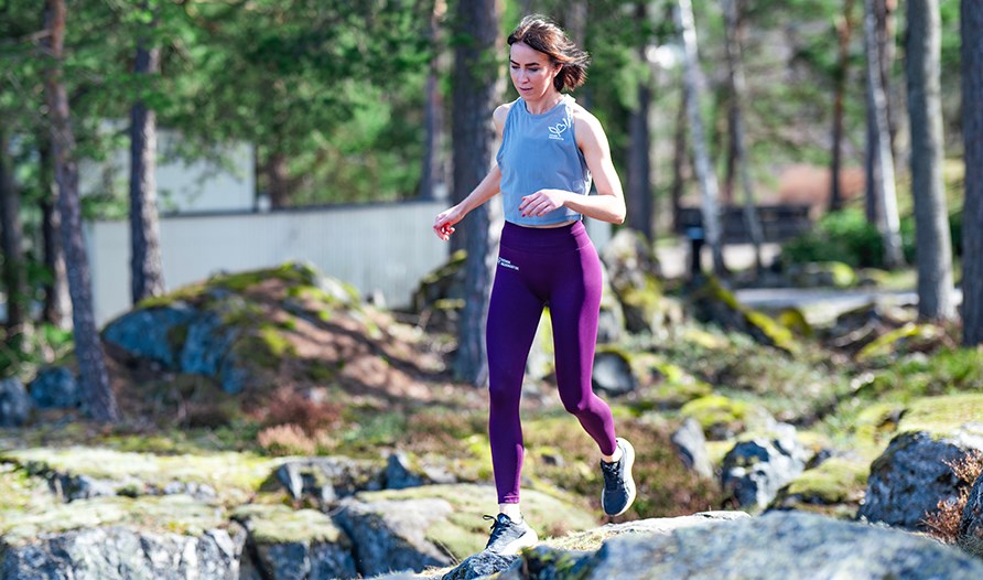 Kvinna springar �ver berg och stenar.