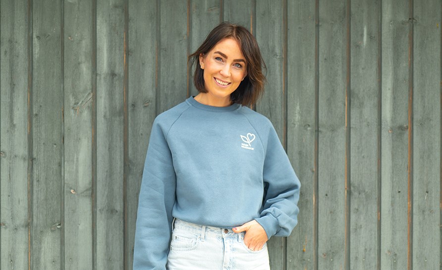 Sofia Ståhl står lutad mot en vägg i ljusblåa kläder Sofia Ståhl står lutad mot en vägg i ljusblåa kläder