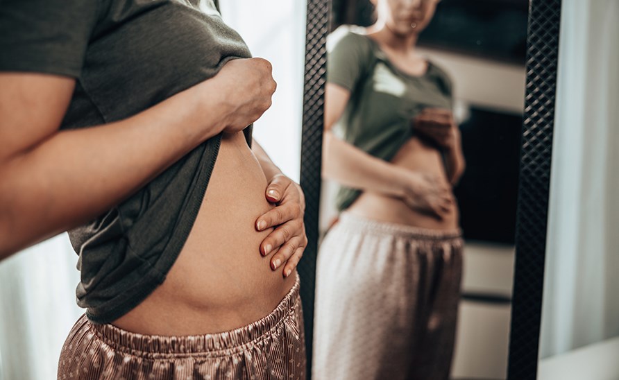 Kvinna som håller sig för magont. Kvinna som håller sig för magont.