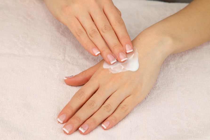 Händer som smörjer in en återfuktande body lotion. Händer som smörjer in en återfuktande body lotion.