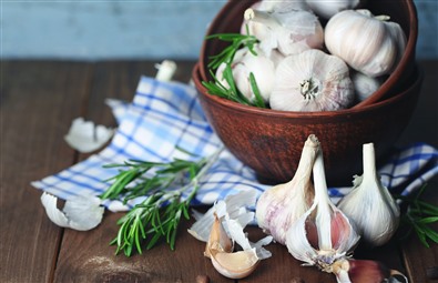 En skål med vitlök på ett träbord. En skål med vitlök på ett träbord.